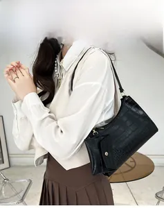 Fashionable black crocodile pattern shoulder bag with small pendant pouch on female model