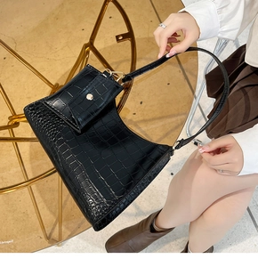 Close-up of black crocodile pattern shoulder bag with a small matching coin purse