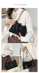 Detail of black stone-patterned underarm bag featuring a mini pouch and gold hardware