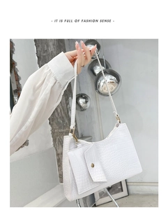 Detail of white crocodile pattern shoulder bag with small attached coin purse charm