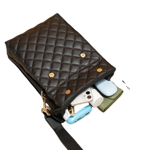 Sac bandoulière matelassé noir avec boucles dorées montrant son grand espace intérieur