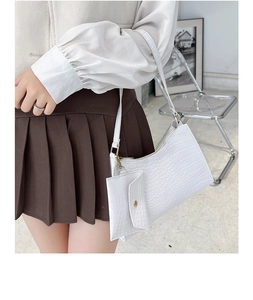 Close-up of white crocodile pattern shoulder bag with a matching small coin purse pendant
