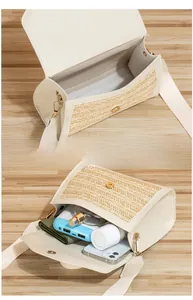 Detail view of straw crossbody bag showing spacious interior for phone and wallet