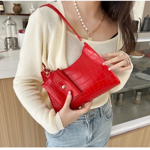 Chic red crocodile texture shoulder bag with mini pouch worn by a model in a cafe