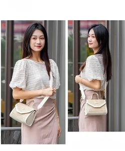 Close-up of summer straw crossbody bag with white leather trim worn by a model