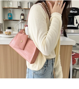 Pink stone pattern underarm bag shown with mini matching pouch in a cafe setting