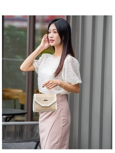 Detail of straw crossbody bag with sequins and cream leather trim on a stylish outfit