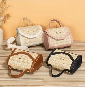 Close-up of textured straw weaving and golden metal buckle on stylish ladies handbags