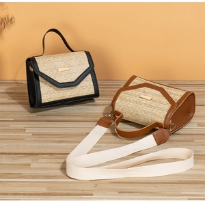 Detail of woven straw handbag with sequin accents, leather trim, and removable canvas strap