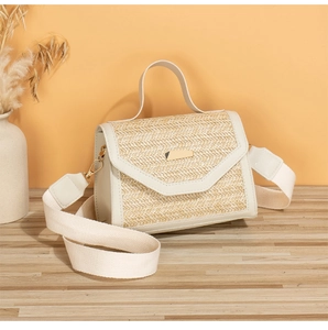 Detail of beige straw bag showing herringbone weave, leather trim, and gold clasp hardware