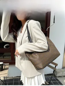 Polka dot pattern tote bag shown with a white blazer in a stylish outdoor setting