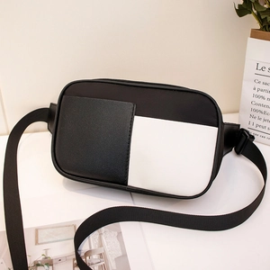 Sac de poitrine minimaliste noir et blanc avec sangle réglable sur surface blanche