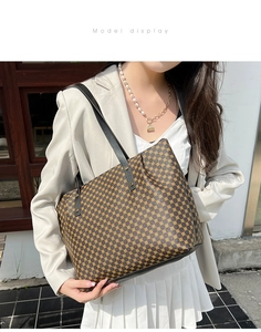 Close-up of retro polka dot tote bag with black leather straps and gold rivets