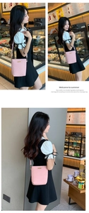 Pink quilted bucket bag with golden buckle shown on a model in a cafe setting