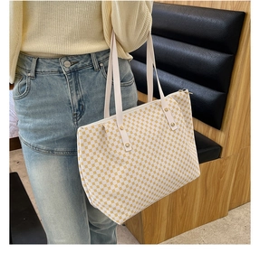 Detailed shot of large capacity tote bag featuring yellow polka dot pattern on white fabric
