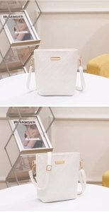 Detail of white embossed bucket bag with golden hardware and adjustable shoulder strap