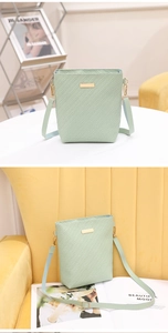 Detailed close-up of mint green woven bucket bag with elegant gold metal chain hardware