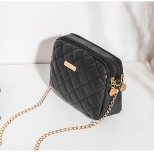 Detail van de zwarte gewatteerde crossbodytas met dubbele ritssluiting en gouden ketting