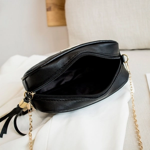 Minimalist black leather crossbody bag with gold chain strap and zipper closure