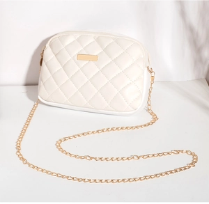 Detail van witte gewatteerde minitas met gouden ketting en ruitvormig stiksel