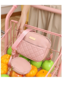 Detailed view of pink quilted crossbody bag and round coin purse in a creative display