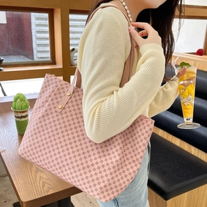 Pink polka dot printed large tote bag with shoulder straps shown in a cafe setting