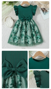 Détail de la robe vert foncé avec nœud 3D, texture en maille et jupon en tulle fleuri