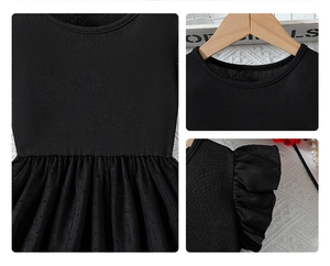Détail de robe noire pour filles avec volants en tulle à pois et col en maille côtelée