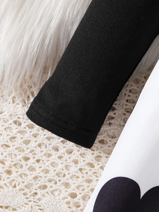 Detailed view of sleeve cuffs with precise double stitching and black polka dot pattern