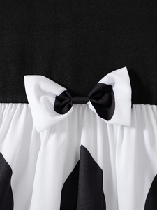 Girl's long-sleeve princess dress with elegant black bodice and white polka dot bow detail