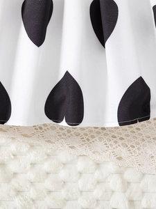 Detailed view of kids princess dress with black heart patterns and vintage lace hem