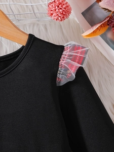 Detalle de vestido para bebé con volantes de cuadros rojos y malla en el hombro