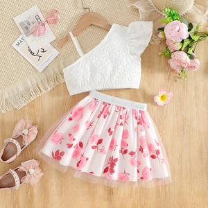 Detail of girls floral mesh skirt with white one-shoulder embossed top and pink shoes