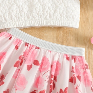 Detail of pink floral tulle skirt with silver elastic waistband and white textured fabric