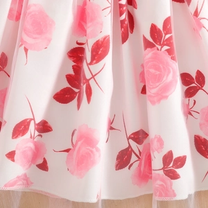 Close-up of white tulle skirt fabric with pink rose prints and red leaf patterns