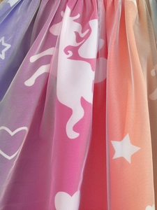 Close-up of rainbow tulle fabric with white unicorn and star patterns for girls skirt