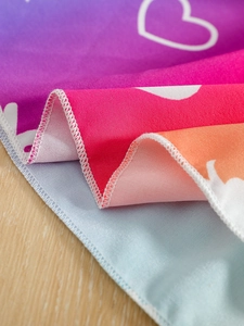 Detail of colorful rainbow mesh fabric with white heart print and high-quality stitching
