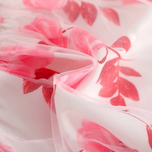 Detailed macro shot of white tulle fabric featuring delicate pink floral prints