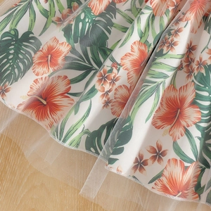 Dettaglio della gonna in tulle con stampa tropicale di ibisco e foglie di monstera