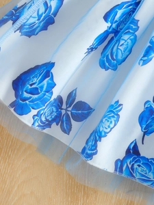 Detailed close-up of blue rose floral print on a pleated tulle skirt with fine stitching