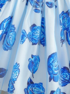 Detail of blue rose print fabric with delicate mesh layer on girls' pleated skirt