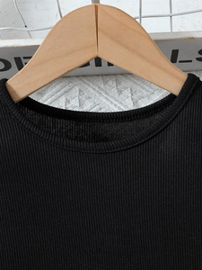 Détail de la robe d'été noire côtelée pour fille avec col rond et texture en maille