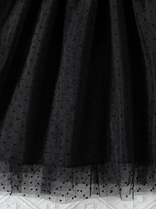 Vue verticale du tissu en maille à pois noirs pour robe d'été de princesse pour filles