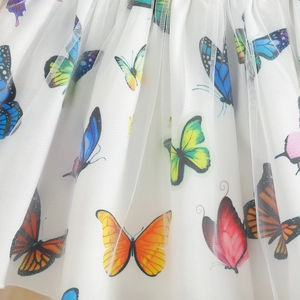 Detailed close-up of double-layer mesh fabric with colorful butterfly prints for girls' skirt