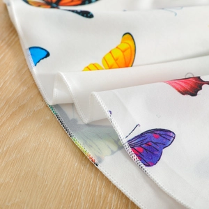 Detail of white tulle skirt with colorful butterfly prints and fine rolled hem edges