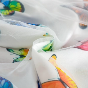 Detail view of white mesh fabric featuring vibrant butterfly prints for toddler skirts