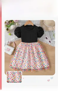 Detail of girls' summer dress featuring a black ribbed bodice and colorful polka dot tulle skirt