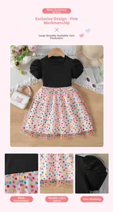 Detail view of girl's summer dress featuring black knit bodice and colorful polka dot mesh skirt