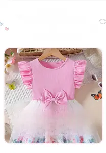 Detail of pink cotton flutter sleeve dress with mesh skirt featuring floral patterns