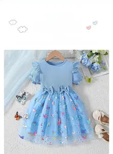 Detail of girls' summer dress with floral mesh skirt, blue ribbons and puff sleeves
